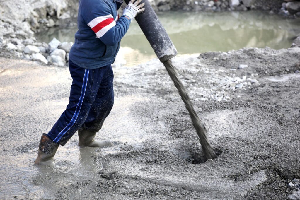 man pouring cement with gravel mix on the ground